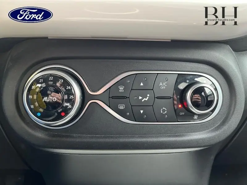 Tableau de bord de Renault Twingo 2019, vue frontale sur commandes de climatisation avec réglage automatique et bouton rotatif.
