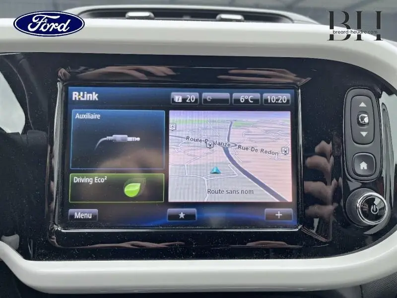 Écran tactile central du système R-Link dans une Renault Twingo Rouge Flamme, affichant la navigation et options audio.
