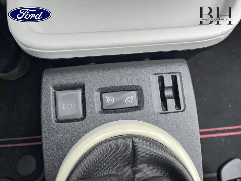 Vue rapprochée du tableau de commande central avec bouton ECO et commandes de régulateur de vitesse sur Renault Twingo Rouge Flamme 2019.