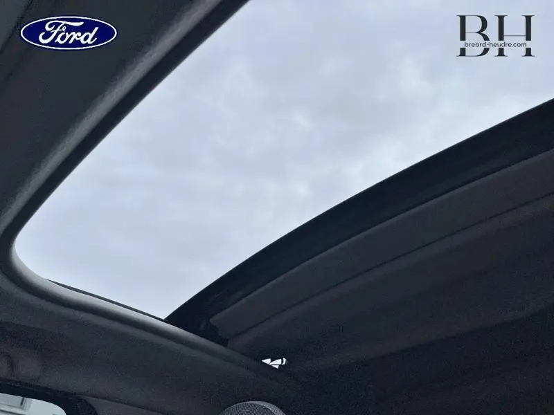 Vue intérieure du toit ouvrant en toile de la Renault Twingo Rouge Flamme, laissant apparaître le ciel gris.