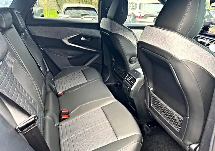 Vue intérieure arrière côté droit du Peugeot 3008 gris titane, montrant les sièges et les aérations centrales.