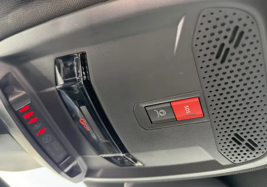 Détail du plafonnier gris avec bouton SOS rouge et éclairage intérieur sur Peugeot 208 Hybrid 145 GT 2024.