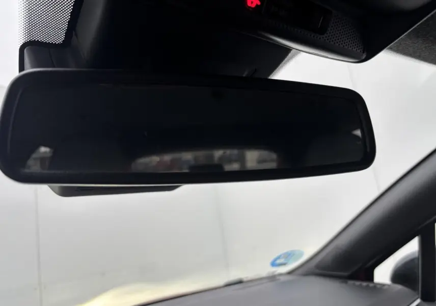 Rétroviseur intérieur noir de Renault Clio V rouge flamme, vue depuis le siège conducteur vers l'avant.