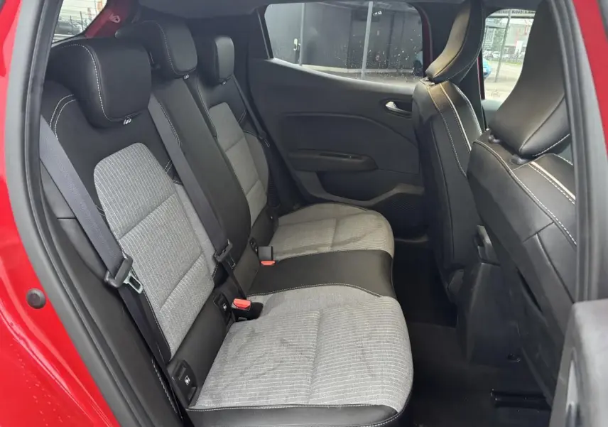 Vue intérieure côté gauche de la banquette arrière grise et noire d'une Renault Clio rouge flamme 2025.