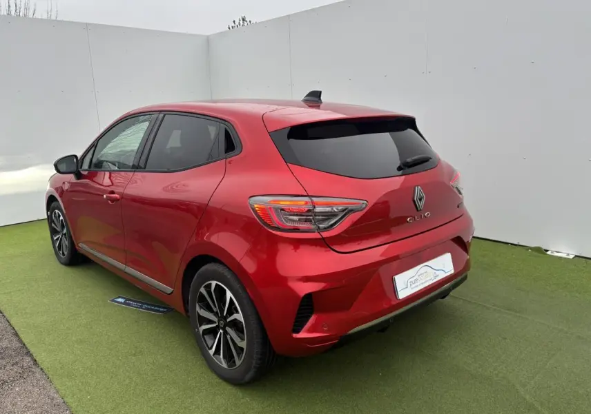 Vue 3/4 arrière droite de la Renault Clio V rouge flamme métal avec feux LED et jantes alliage 16 pouces.