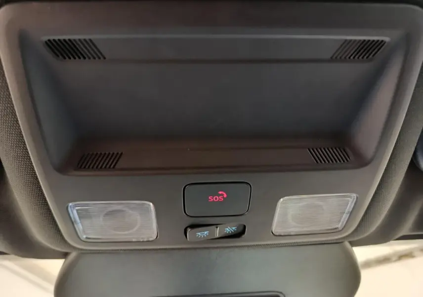 Gros plan sur le plafonnier intérieur noir du Ford Kuga 2024 avec bouton SOS et éclairages intégrés.