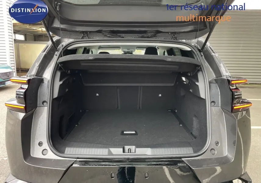 Coffre ouvert en vue arrière d’un Citroën C5 Aircross Hybrid gris platinium métal, avec feux arrière allumés.