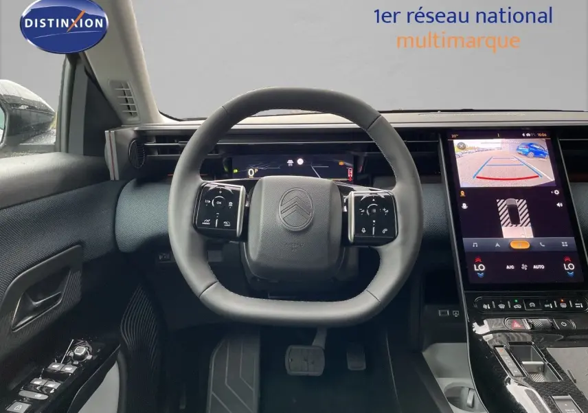 Vue intérieure du poste de conduite du Citroën C5 Aircross Hybrid 145ch, volant cuir et écran tactile central allumé.