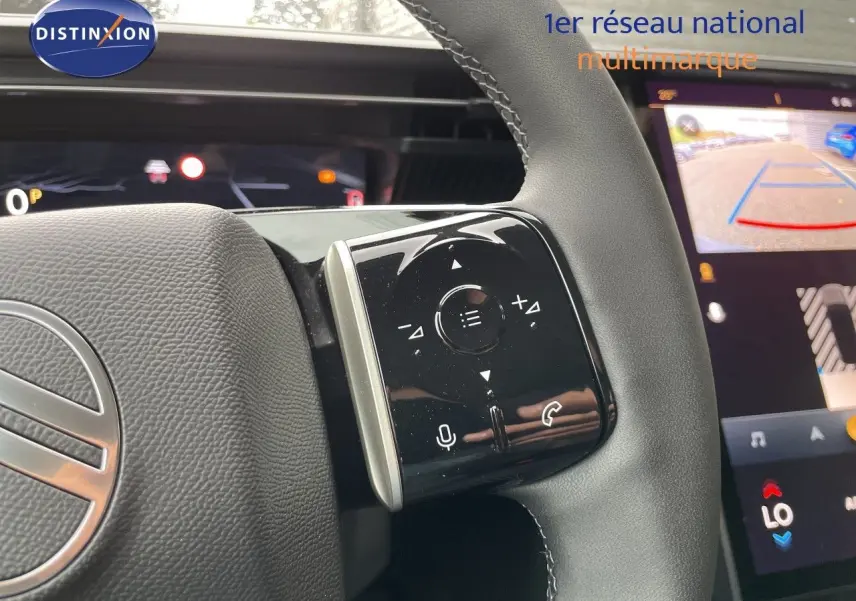 Gros plan sur le volant cuir noir du Citroën C5 Aircross gris platinium, avec commandes tactiles et écran multimédia en arrière-plan.