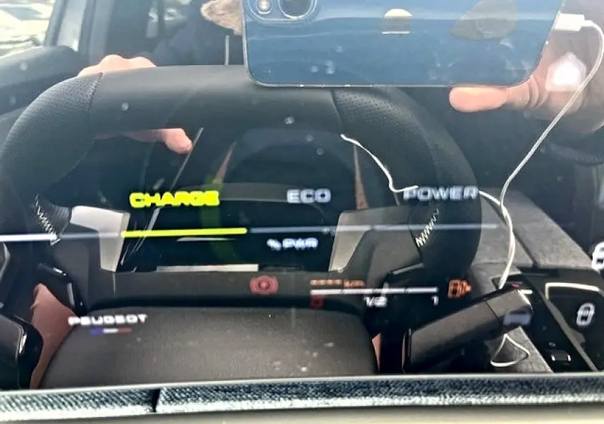 Vue rapprochée du tableau de bord numérique du Peugeot 3008 gris, affichant les modes Charge, Eco et Power.