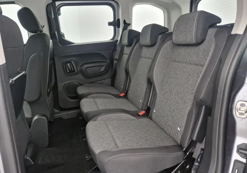 Vue latérale des trois sièges individuels arrière gris du Opel Combo Life Gris Artense avec habillage tissu et ceintures visibles.