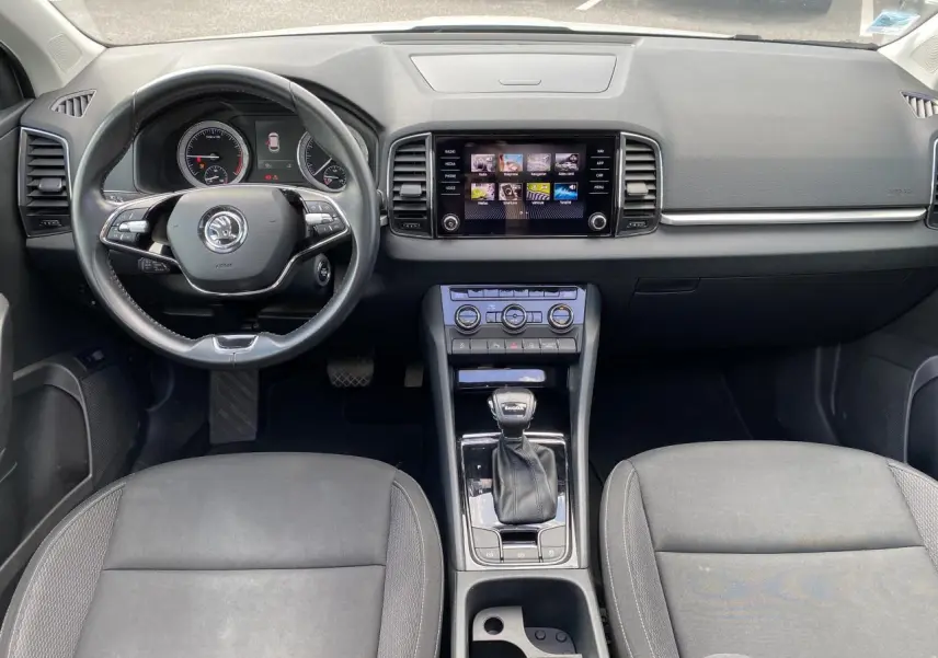 Vue intérieure avant du Skoda Karoq 2022 avec tableau de bord noir, écran tactile et levier de vitesse DSG7.