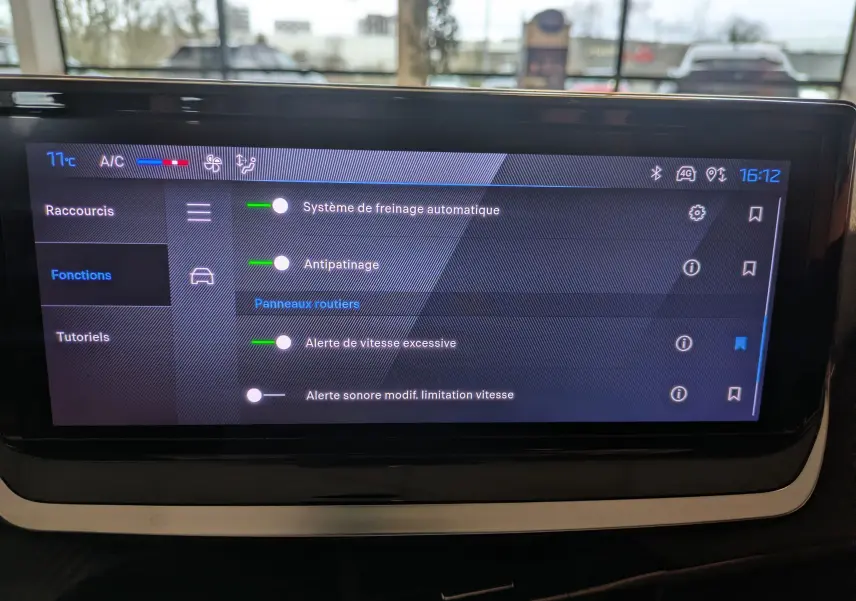 Écran tactile intérieur de la Peugeot 208 2024 affichant les réglages d’aides à la conduite et la climatisation.