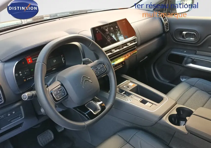 Intérieur noir du Citroën C5 Aircross 1.2 Hybride 145ch, vue côté conducteur sur tableau de bord et console centrale moderne.