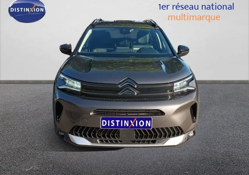 Vue avant centrée du Citroën C5 Aircross gris platinium métal avec calandre noire et phares LED allumés.