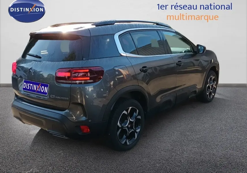 Citroën C5 Aircross gris platinium métal en 3/4 arrière droit, avec jantes bi-ton et feux LED allumés.