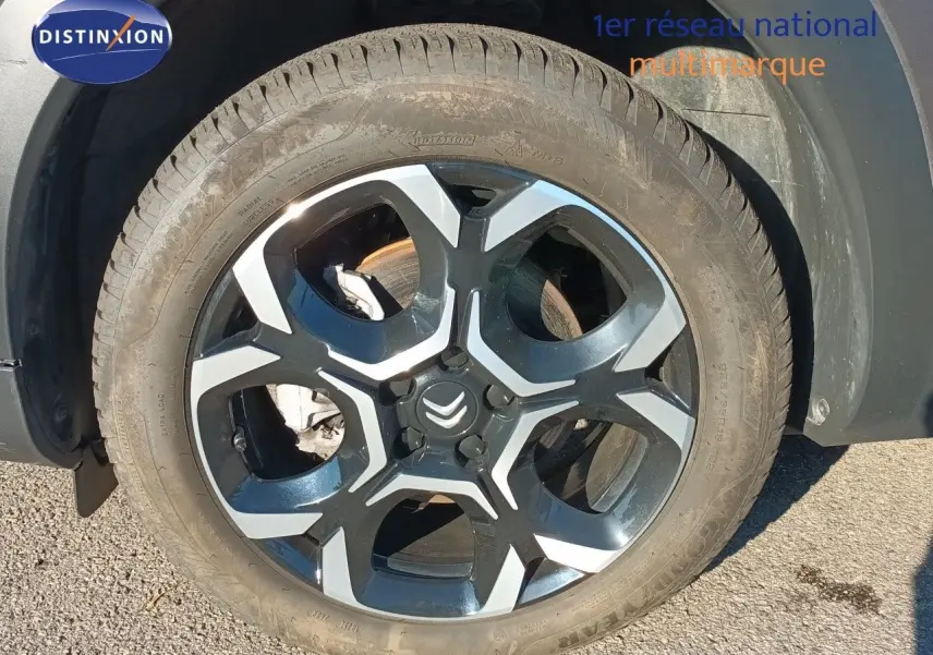 Gros plan sur la roue avant droite du Citroën C5 Aircross gris platinium métal avec jante alliage bicolore.