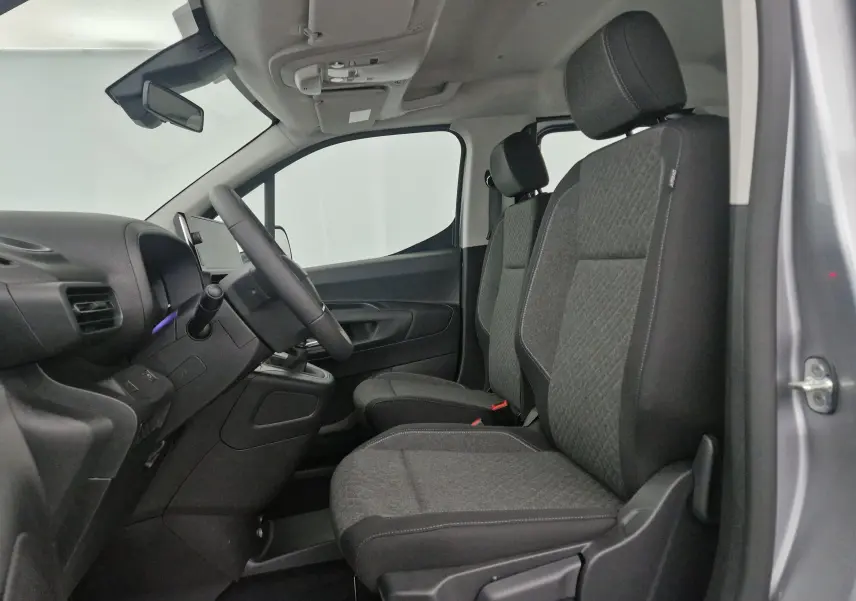 Intérieur avant de l'Opel Combo Life gris Artense, vue côté conducteur montrant les sièges tissu et le tableau de bord simple.