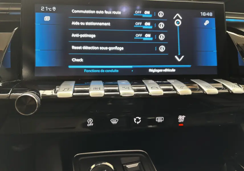 Écran tactile central et rangée de boutons métalliques dans l'habitacle d'une Peugeot 508 gris foncé de 2019.