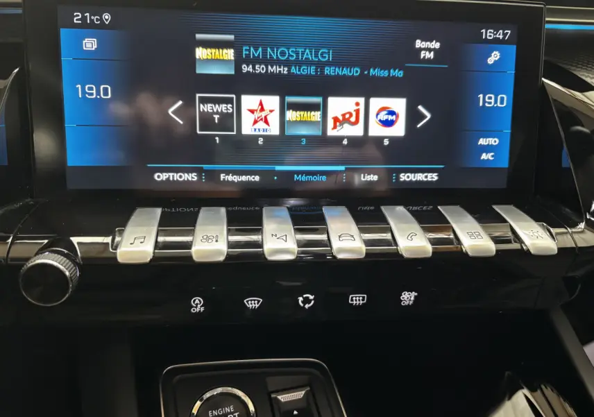 Vue rapprochée de la console centrale tactile du Peugeot 508 gris foncé, affichant radio FM et commandes piano.