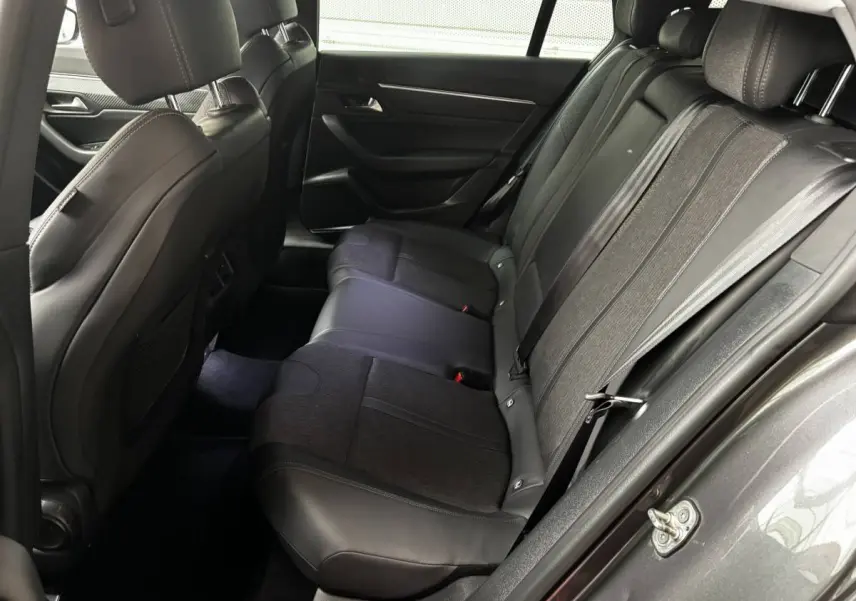 Vue côté droit de l'habitacle arrière d'une Peugeot 508 gris foncé, sièges en cuir et tissu noir.