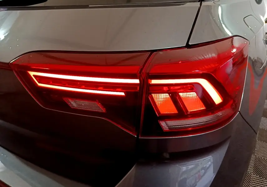 Gros plan sur le feu arrière droit rouge allumé du Volkswagen T-Roc gris foncé, version 2022.