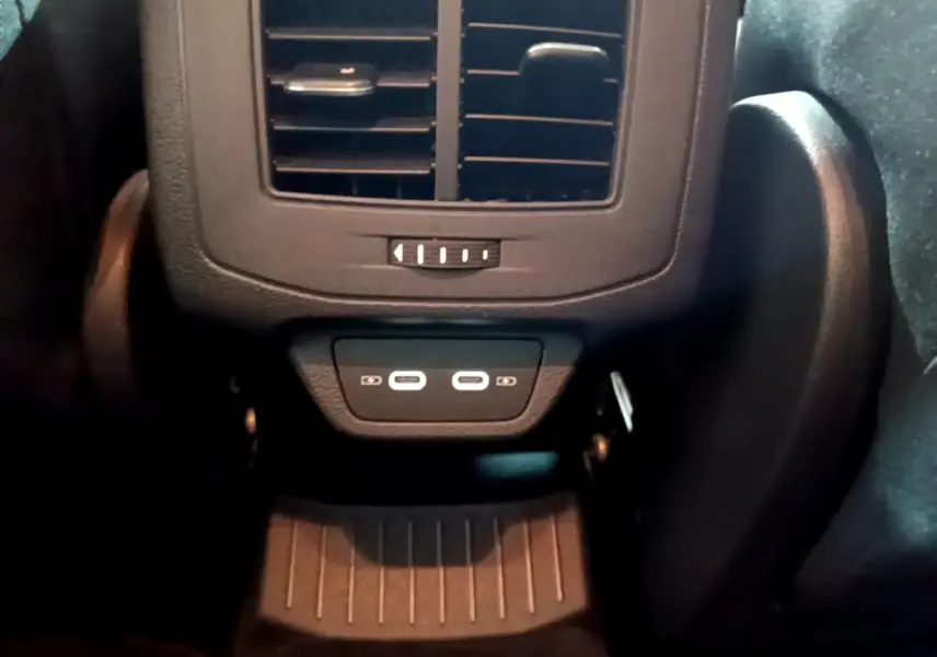 Détail des ports USB-C arrière et sortie d’air noir dans l’habitacle du Volkswagen T-Roc gris foncé.