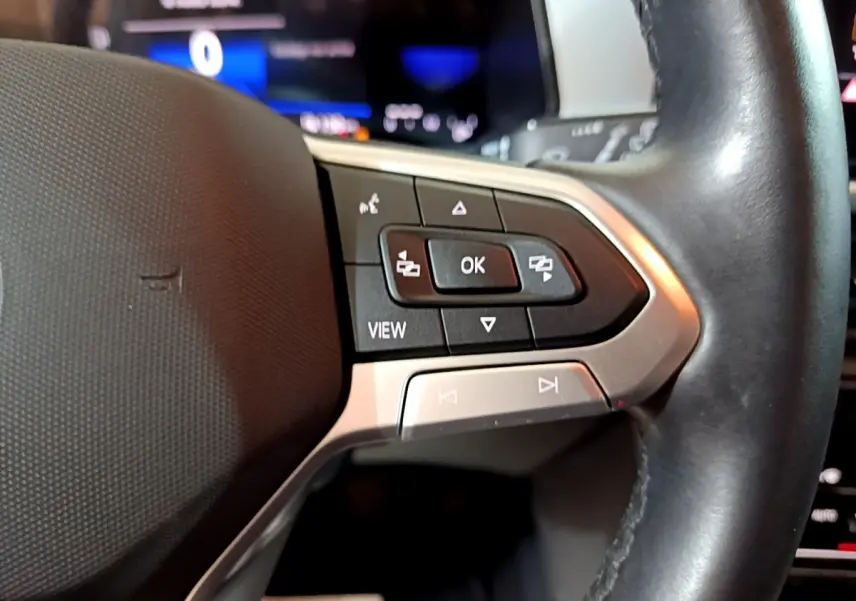 Gros plan sur les commandes multifonctions du volant cuir noir du Volkswagen T-Roc gris foncé, version 2022.