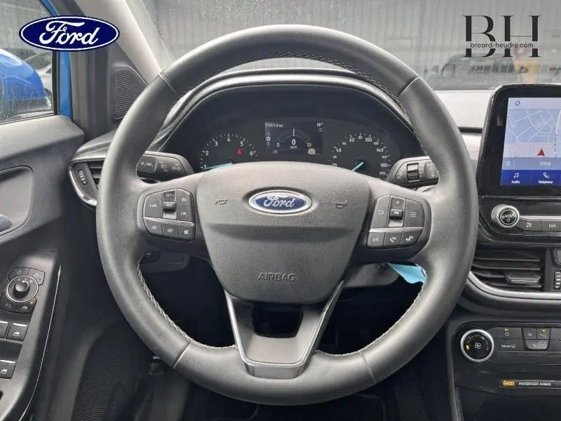 Vue rapprochée du volant multifonction noir et du tableau de bord digital du Ford Puma 2022 Fashion Bleu Island.