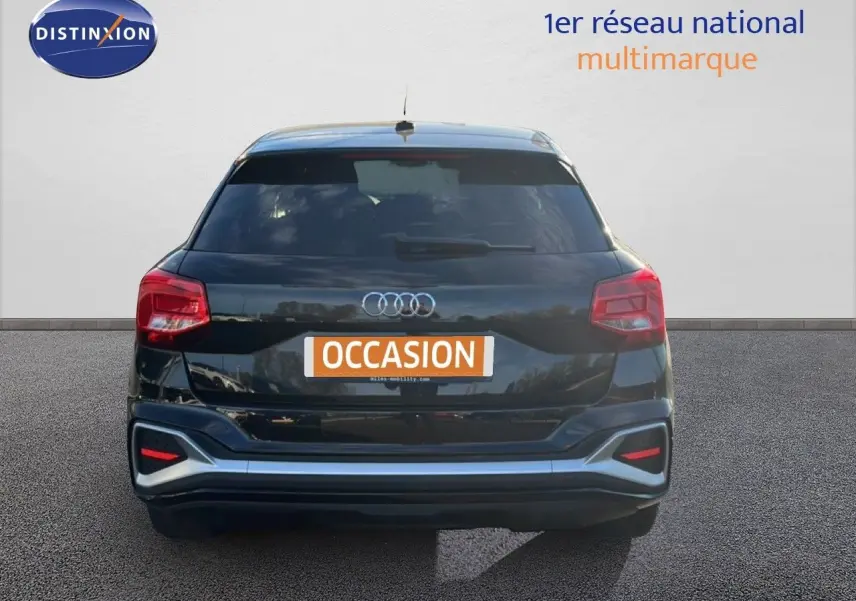 Vue arrière d'un Audi Q2 noir mito metal 2023 avec feux rouges et logo quatre anneaux bien visibles.