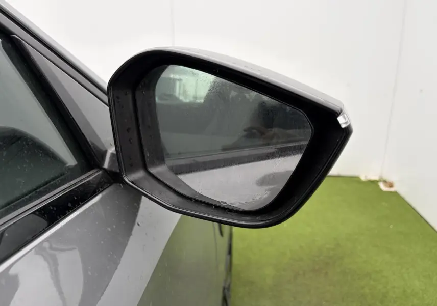 Rétroviseur côté gauche d’une Peugeot 308 gris selenium, avec carrosserie et vitre partiellement visibles.