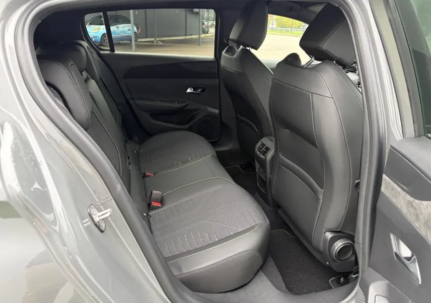 Vue côté gauche de l’habitacle arrière d’une Peugeot 308 gris selenium avec sièges cuir et surpiqûres vert Adamite.