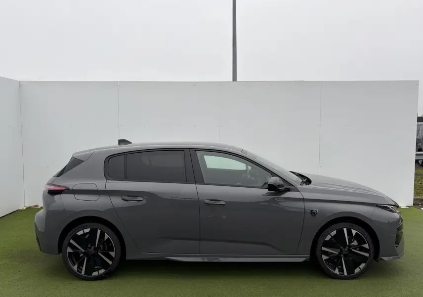 Profil droit d'une Peugeot 308 III gris selenium avec jantes alliage noires et vitres surteintées.