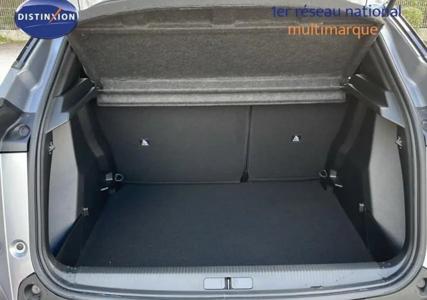 Coffre ouvert vu de l'arrière d'un Peugeot 2008 gris 2025, montrant un espace de chargement vide et propre.