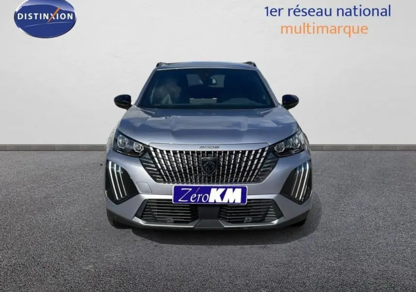 Vue de face d'un Peugeot 2008 gris 2025 avec calandre imposante et feux diurnes LED verticaux allumés.