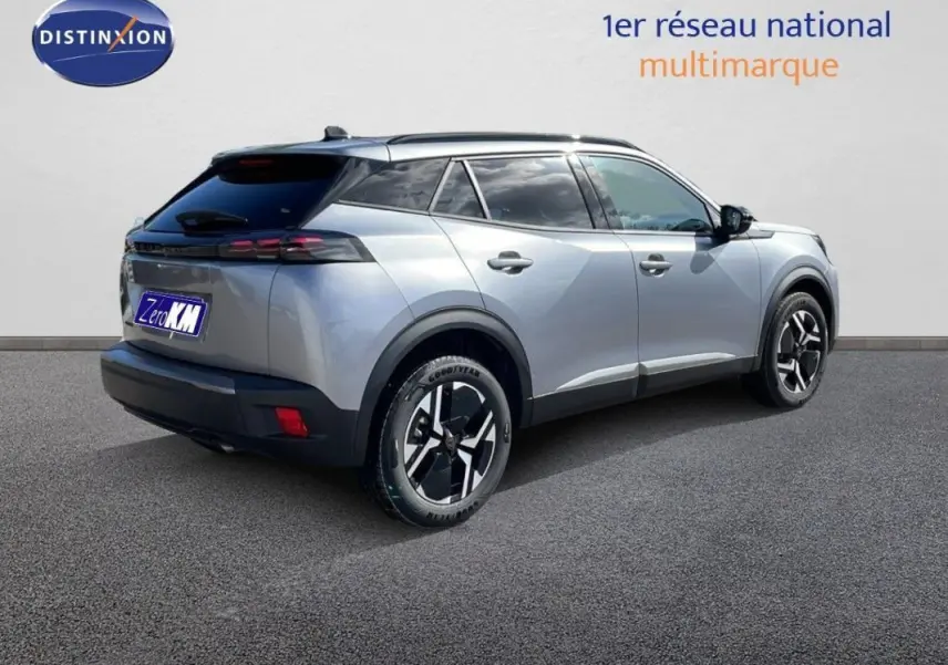 Peugeot 2008 gris vue 3/4 arrière droit, avec barres de toit et jantes aluminium distinctives.