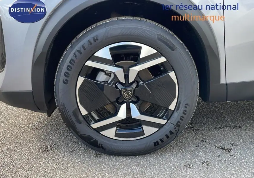 Gros plan sur la jante aluminium noire et argentée d’un Peugeot 2008 gris, côté avant droit.