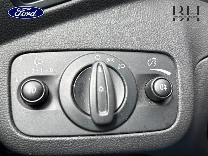 Gros plan sur le bouton de commande des phares et feux antibrouillard du tableau de bord d'une Ford C-MAX blanc glacier 2019.