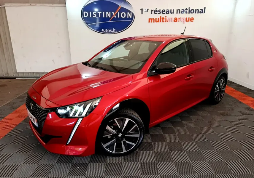 Peugeot 208 rouge vue en 3/4 avant droit, avec jantes noires et signature lumineuse LED verticale.