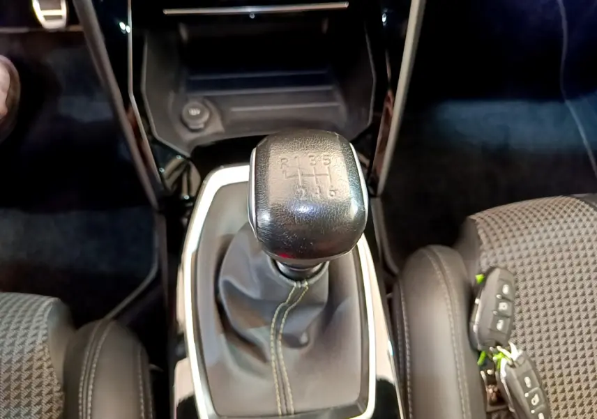 Le levier de vitesse manuel noir de la Peugeot 208 GT Line 2020, entouré de sièges gris et cuir noir.