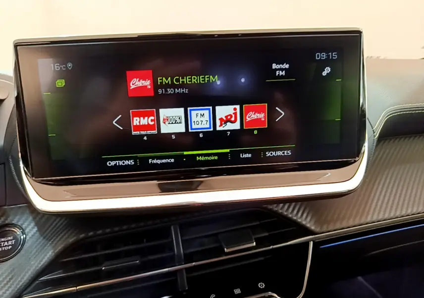 Écran tactile 10 pouces du tableau de bord de la Peugeot 208 GT Line 2020 affichant les stations radio FM.