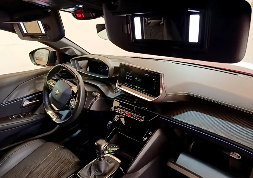 Intérieur de la Peugeot 208 GT Line 2020, vue côté conducteur, tableau de bord avec écran tactile 10 pouces et volant cuir.