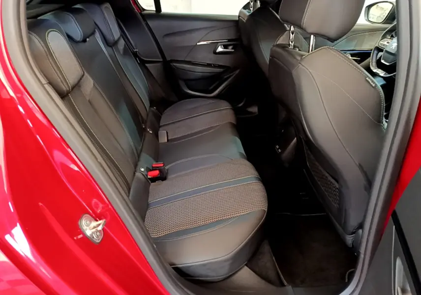 Vue intérieure côté arrière droit montrant la banquette arrière en cuir noir de la Peugeot 208 rouge GT Line 2020.