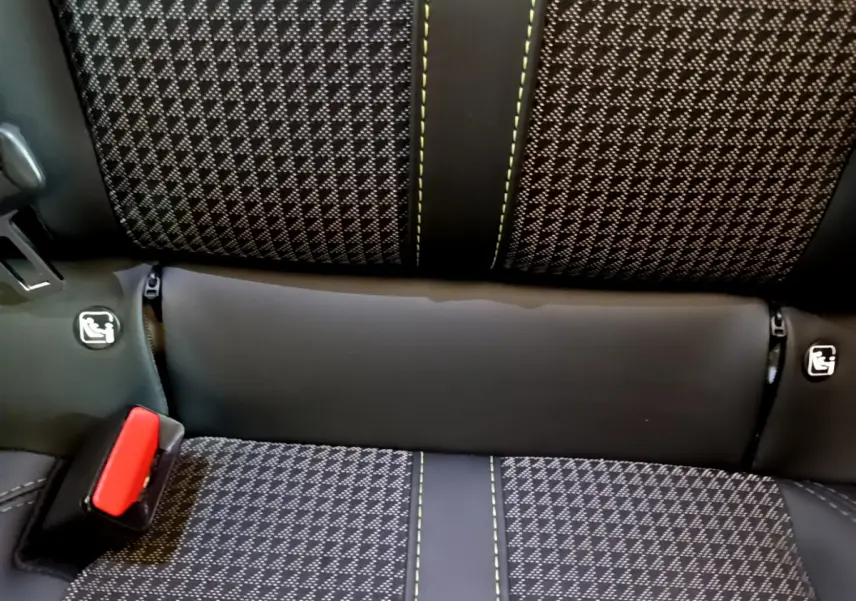 Gros plan sur la banquette arrière du Peugeot 208 GT Line 2020, tissu noir à motifs et surpiqûres vertes avec ceinture rouge.
