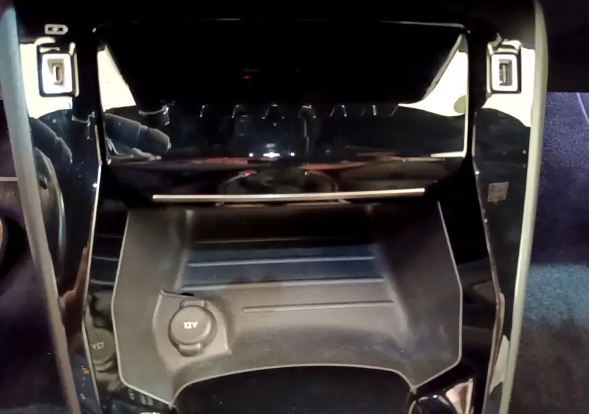 Prise 12V et rangement central noir brillant dans l'habitacle de la Peugeot 208 GT Line rouge 2020