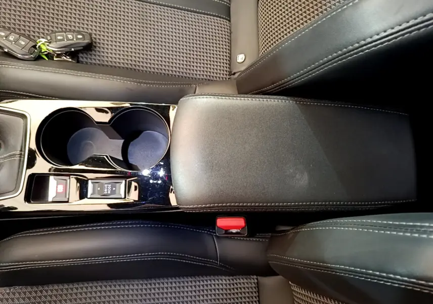 Vue plongeante sur la console centrale noire et les sièges en tissu à motifs de la Peugeot 208 GT Line rouge 2020