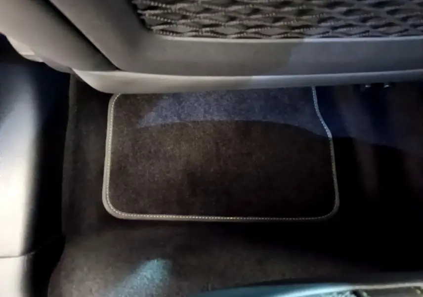 Gros plan sur le tapis de sol noir côté arrière d'une Peugeot 208 GT Line rouge de 2020.