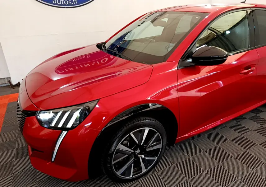 Vue 3/4 avant droit d'une Peugeot 208 GT Line rouge avec phares LED et jantes alliage noires.