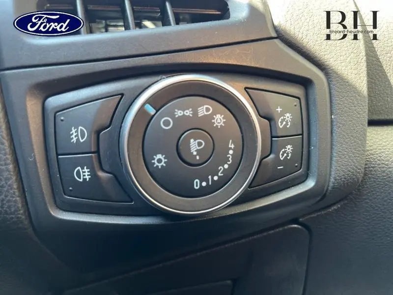 Gros plan sur le sélecteur d'éclairage intérieur noir de la Ford Focus blanc glacier 2017, avec commandes de phares et réglages.