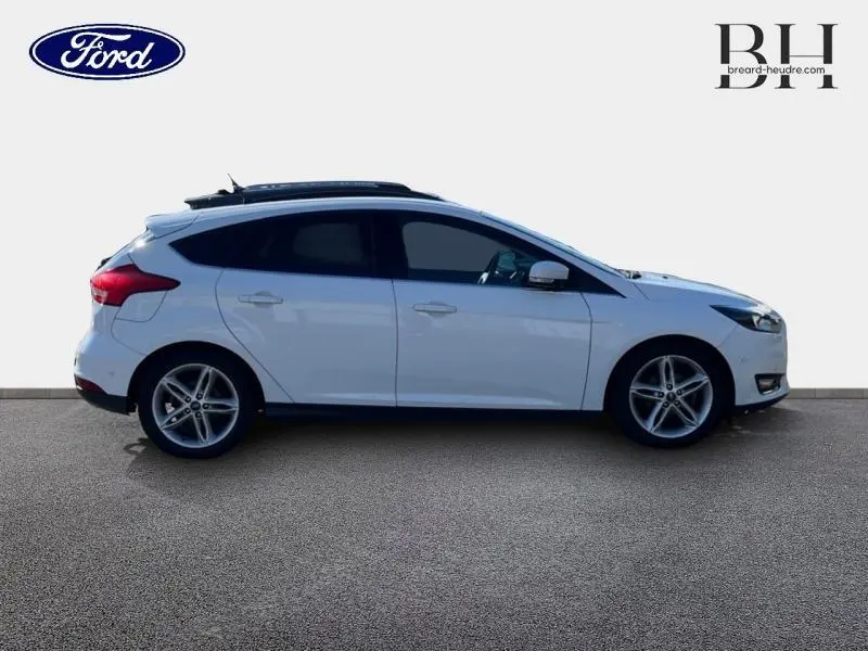 Profil droit d'une Ford Focus blanc glacier 2017 avec jantes alliage et toit ouvrant panoramique.